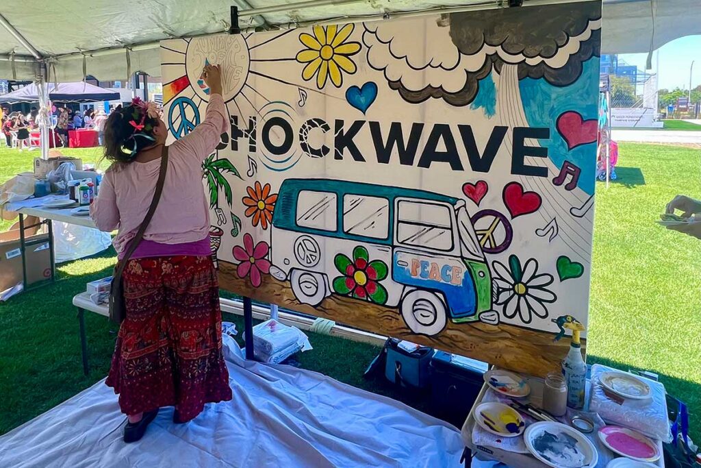 A person painting on a life size mural