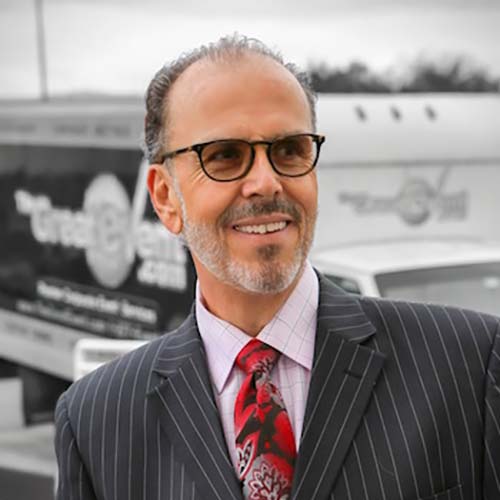 Photo of Darryl Scotti - a photo of a smiling man in a suit and tie, standing in front of a truck with The Great Event branding